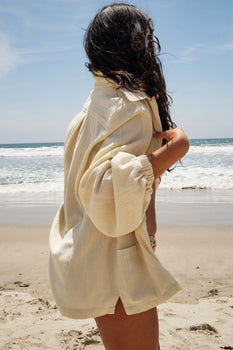 woman at the beach wearing an alabaster jacket over a bikini
