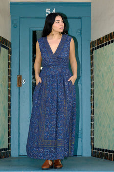 woman wearing a navy tapestry dress standing in a porch