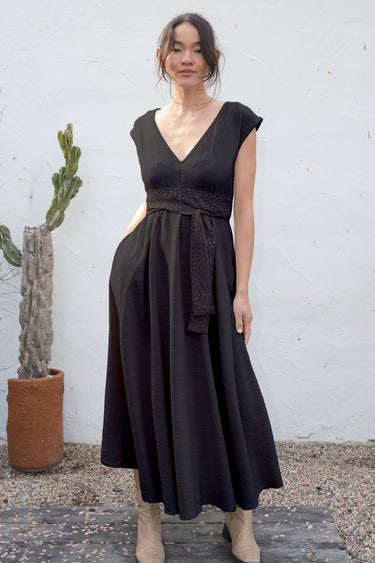 Woman wearing a black dress with a cactus plant in the background