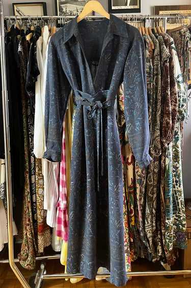 Blue dress hanging on a rack with various other clothes in the background