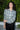 Woman outdoors wearing a gray with white and yellow ikat zip front jacket with black pants.
