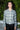 Woman outdoors wearing a gray with white and yellow ikat zip front jacket with black pants.