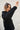 Person wearing a black shirt against a light background