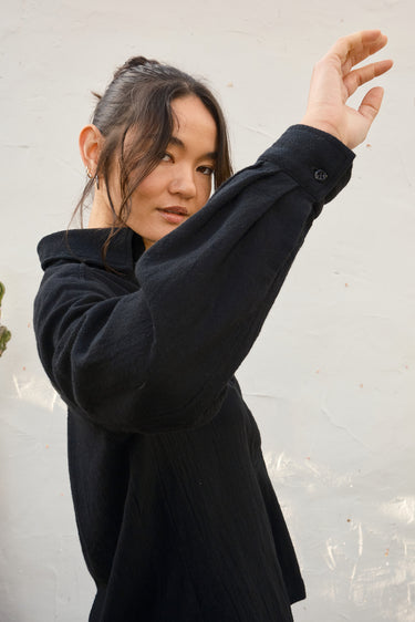 Person wearing a black shirt against a light background
