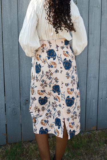 Person wearing a floral dress with a plain background