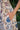 Close-up of a hand holding a floral-patterned fabric with a natural background