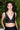 Person wearing a black sleeveless top against a green leafy background
