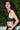 Person wearing a black top against a green leafy background