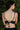Person wearing a black bikini top with thin straps against a green leafy background