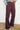 Person wearing black fig flared pants against a white wall.