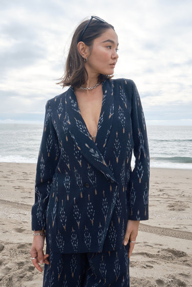 Woman at the beach wearing an ikat double breasted jacket with matching trousers.