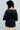 Person wearing a black top with a neutral background