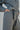 Gray jumpsuit with a belt around the waist on a neutral background