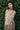 Woman wearing a floral dress standing against a green leafy background