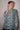 Woman wearing a patterned blouse against a plain background