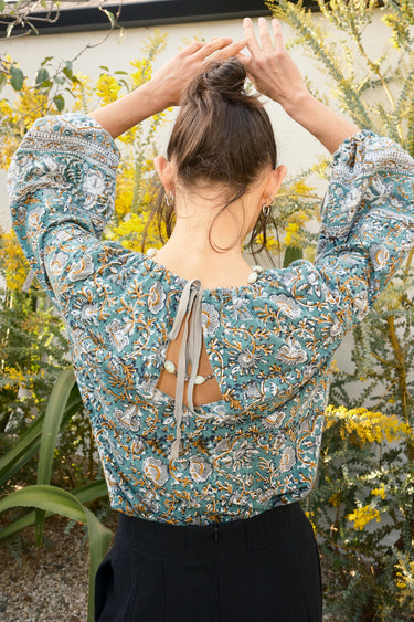 Woman wearing a floral blouse with a blurred natural background