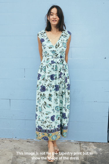 Woman wearing a floral dress against a blue wall
