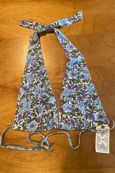 A floral printed bikini top with ties around the neck and back, displayed on a flat surface.