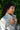 Woman wearing a patterned jacket against a green leafy background