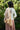 Person wearing a ivory blouse with a jacket over her shoulder showing the lining in a garden setting