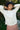woman wearing a white pleated blouse in an outdoor setting 