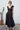 Woman wearing a black dress with a cactus plant in the background