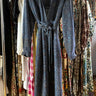 Blue dress hanging on a rack with various other clothes in the background