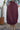 Person wearing a burgundy skirt with a cactus plant in the background