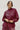 Woman wearing a maroon outfit against a white background