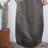 Person wearing a pewter skirt standing in front of a white wall with a cactus plant.