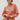 Woman wearing persimmon blouse with lace details against a white background