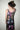 Person wearing a black sleeveless dress with colorful celestial pattern against a plain background