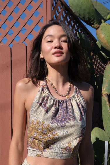 Woman wearing a patterned top standing in front of a cactus plant