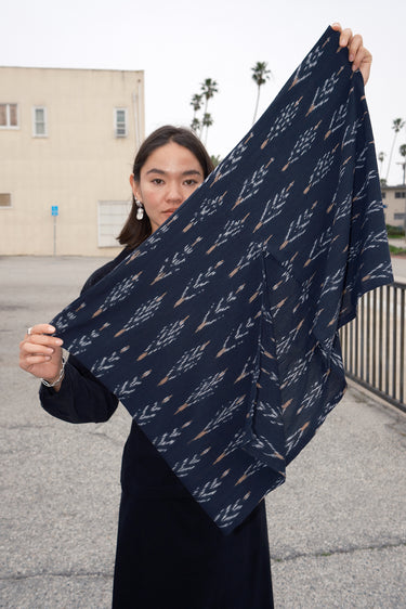 Woman holding an Ikat zero waste shrug to show that the shape is really a rectangle. 