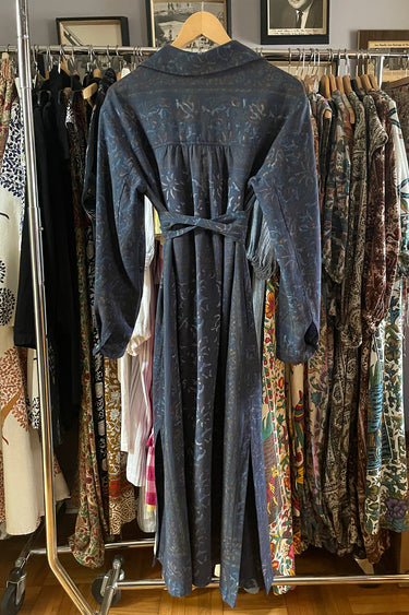 Blue dress hanging on a rack with various other clothing items in the background