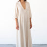 woman standing in photo studio wearing a maxi alabaster caftan with deep v neck and balloon sleeves
