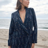 Woman at the beach wearing an ikat double breasted jacket with matching trousers.