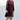 Woman wearing a black fig coat over print skirt with a white background