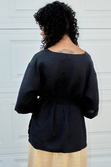 Person wearing a black top with a neutral background