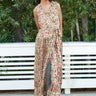 woman wearing a floral pleated dress in front of greenery 