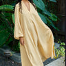Woman wearing a long mimosa dress standing in a garden setting