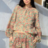A woman wearing a floral handloom tapestry short short with front pockets and deep tucks.