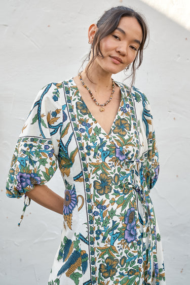 A woman modeling a maxi dress with a tree of life print, featuring voluminous 3/4 sleeves and a V-neckline.