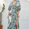 A woman modeling a maxi dress with a tree of life print, featuring voluminous 3/4 sleeves and a V-neckline.