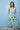 Woman wearing a floral dress against a blue wall