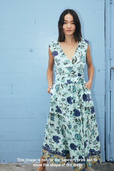 Woman wearing a floral dress against a blue wall
