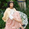 Woman sitting on a white bench in a garden setting