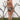 A woman standing outside by a white wall wearing beige, black and brown handloom tapestry bikini with a high rise bottom and matching bikini bra top. Back View